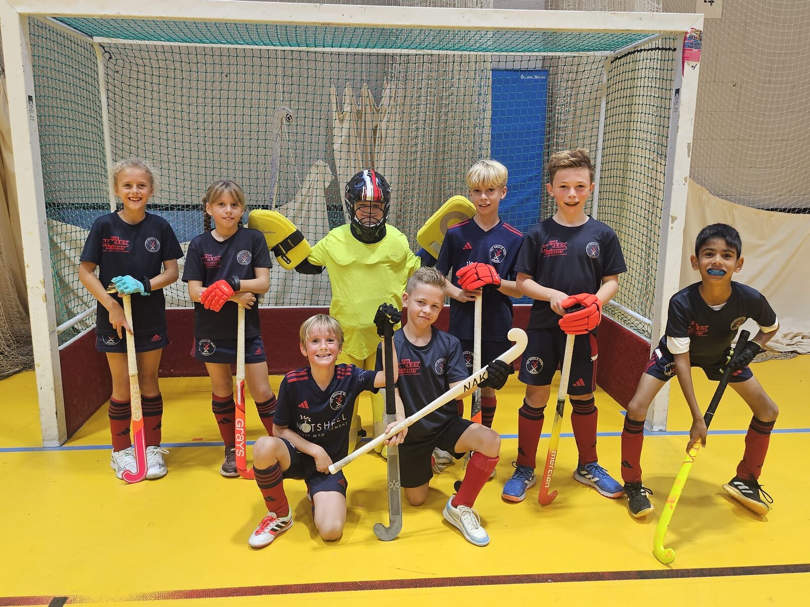 The HC Knole Park U10 squad lined up in front of the goal at the Canterbury indoor festival