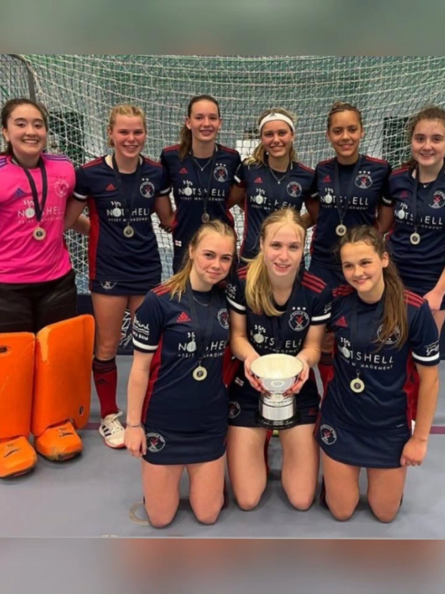 HC Knole Park girls' indoor squad celebrating with the trophy
