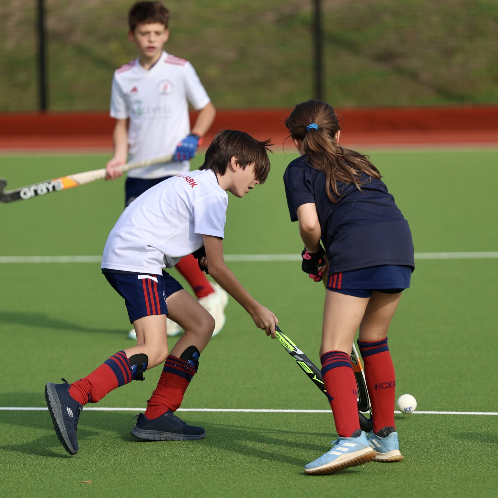 A boy and girl battle for the ball in the morning sunshine