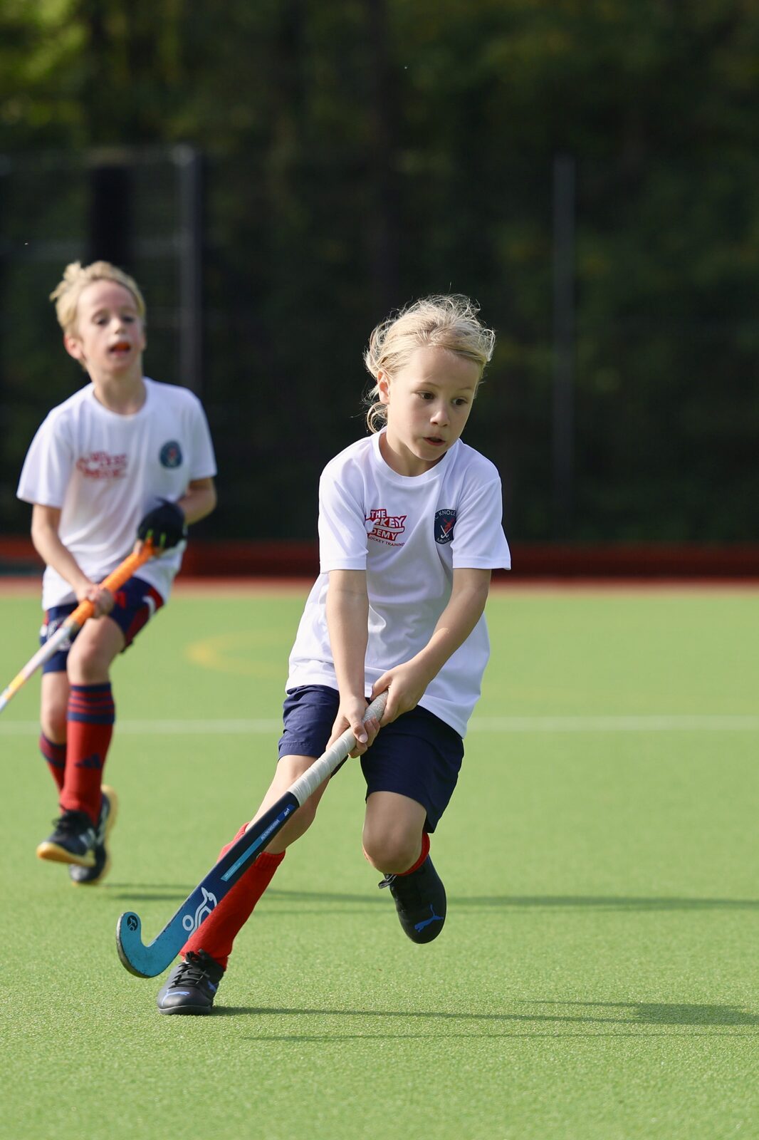 Two teammates in white work the ball forward together