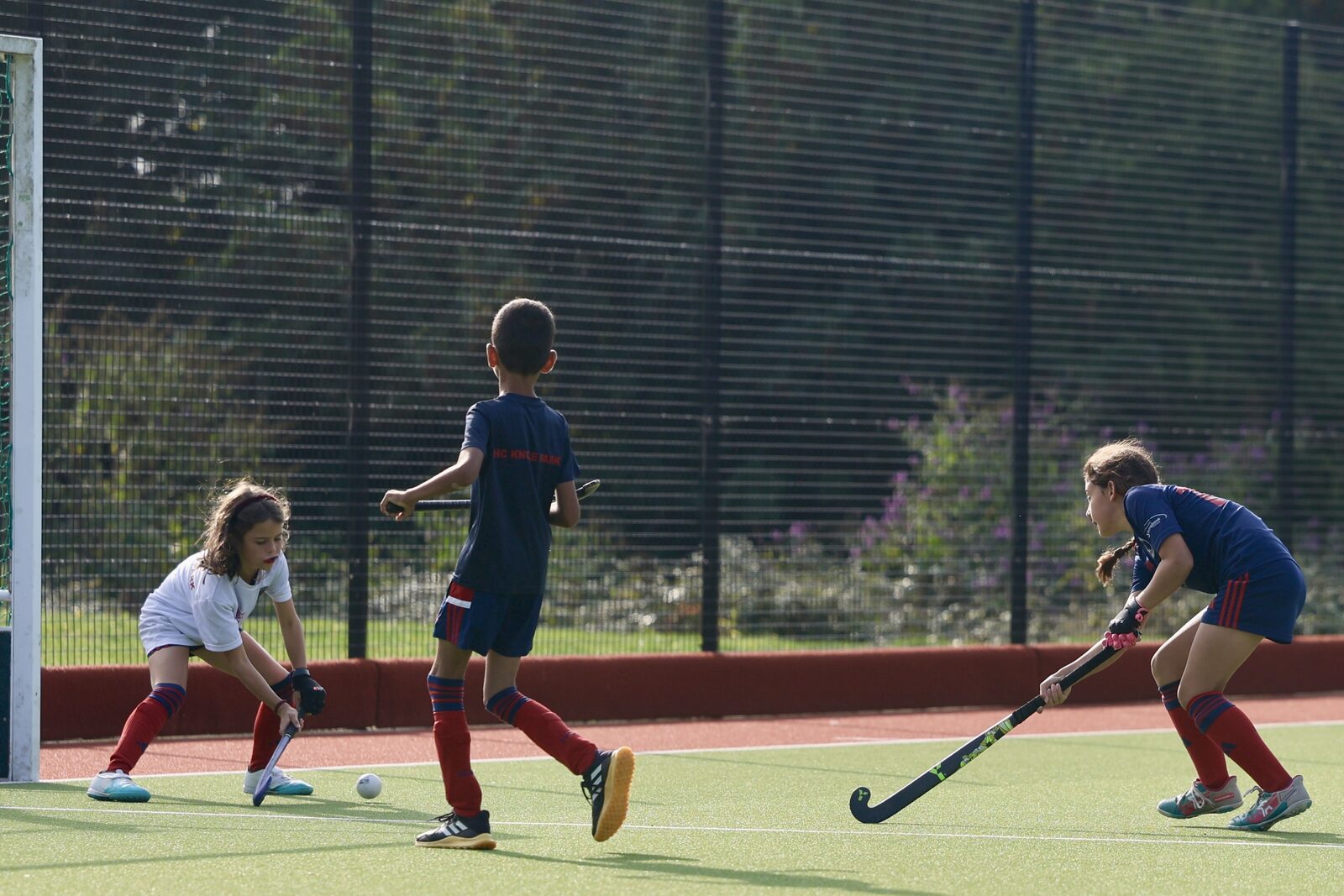Two girls sprint side by side chasing the play