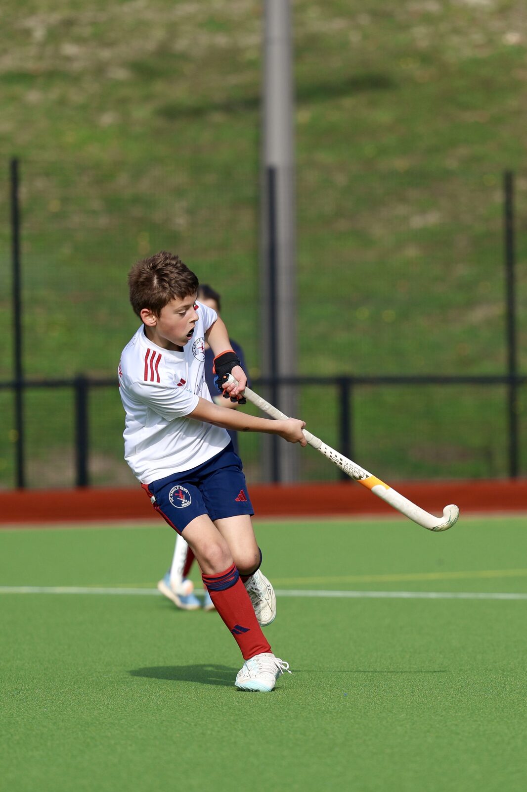 A big swing at goal from a junior in the white bib
